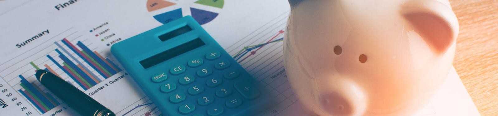 Gebühren Ein Sparschwein, Taschenrechner und Kugelschreiber sind auf einigen Unterlagen platziert.