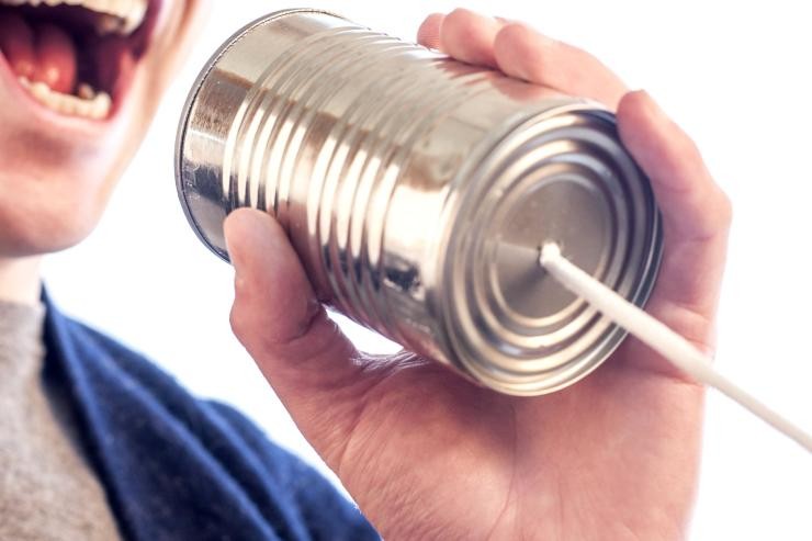 Ein Mann spricht in eine Konservendose