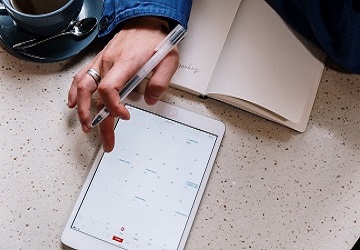 Abfallwirtschaft im Wandel Eine Hand  tippt mit dem Finger auf dem Kalender auf einem Tablet